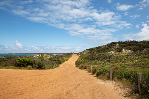 A wide road leading to the ocean that meanders through the shrubs - Australian Stock Image