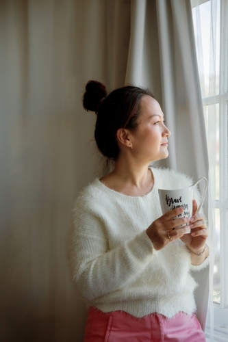 A woman drinking tea at home - Australian Stock Image