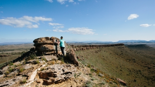 A woman in hiking gear overlooking the rugged landscape of the Flinders Ranges - Australian Stock Image