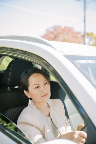 A woman sitting behind the wheels driving to work