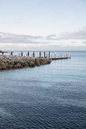 A wooden dock over a pristine calm water - Australian Stock Image