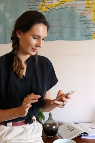 A young creative female worker using her mobile phone - Australian Stock Image