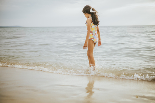 A young girl walking along the beach - Australian Stock Image