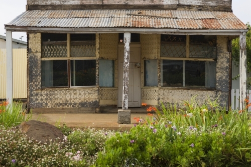 Abandoned and derelict shopfront with flowers in remote NSW - Australian Stock Image