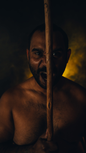 Aboriginal Male portrait yelling with spear - Australian Stock Image