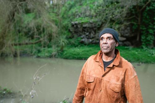 Aboriginal Man in his Forties Standing by River - Australian Stock Image