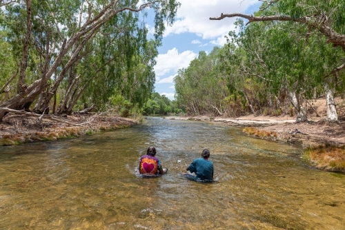 Aboriginal people sitting in river