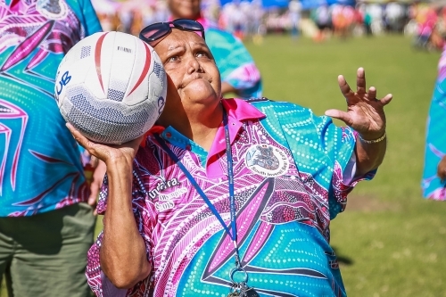 Aboriginal woman aiming getting ready to throw netball - Australian Stock Image