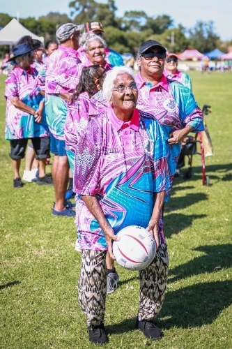 Aboriginal woman crouching to throw netball - Australian Stock Image