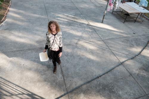 Aboriginal Woman in Backyard Looking up at Camera - Australian Stock Image