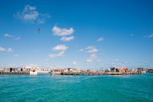 Abrolhos Island crayfishing scene with fishing shacks, jetties, and crayboats - Australian Stock Image