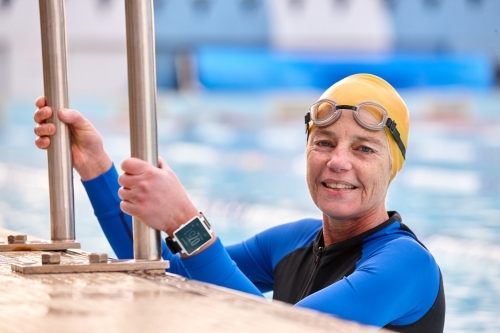 Active senior lady exercising in swimming pool - Australian Stock Image