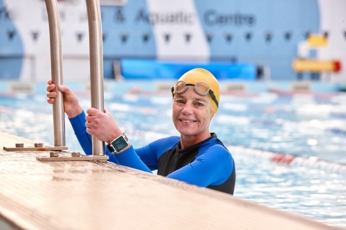 Active senior lady exercising in swimming pool - Australian Stock Image