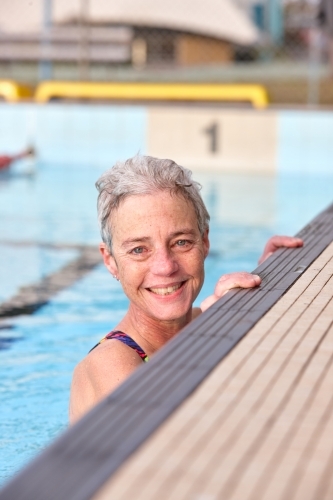 Active senior lady exercising in swimming pool - Australian Stock Image