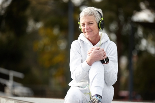 Active senior listening to music with headphones - Australian Stock Image