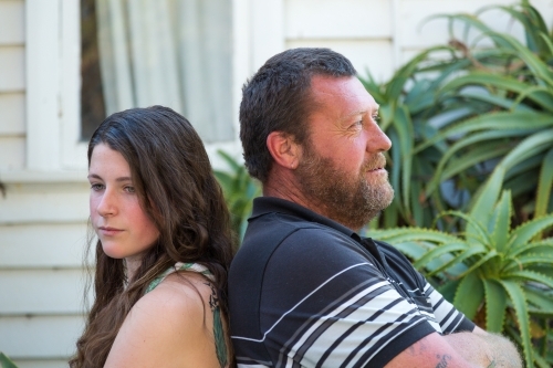 Adult man and teenage girl back to back - Australian Stock Image