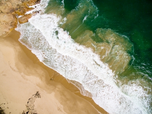 aerial of surf on sandy beach - Australian Stock Image