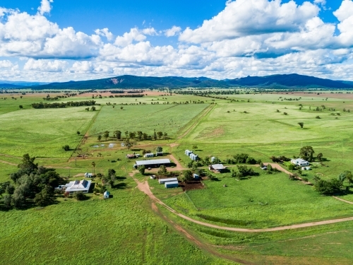 Aerial scene of farm sheds and house among green paddocks - Australian Stock Image