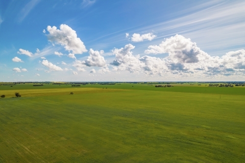 aerial shot of a big open field under cloudy blue skies - Australian Stock Image