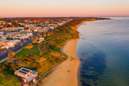 Aerial view a bay side beach with a surf life saving club house - Australian Stock Image