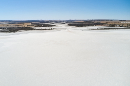 Aerial view of a dry salt lake in Western Australia under clear blue skies. - Australian Stock Image