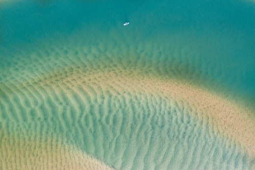 Aerial view of a kayak amongst tidal sandbars and blue water - Australian Stock Image