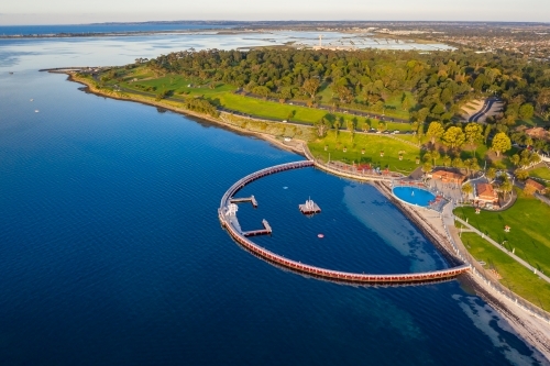 Aerial view of a large circular swimming enclosure along a coastal waterfront - Australian Stock Image