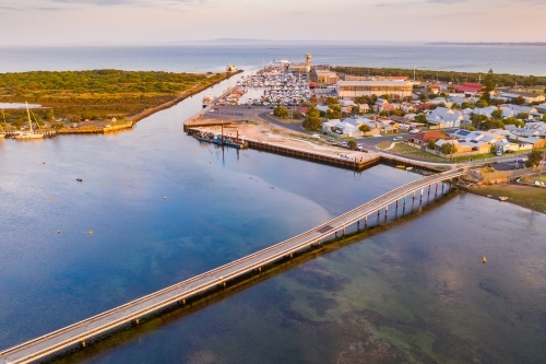 Aerial view of a narrow bridge over a shallow coastal bay at twilight - Australian Stock Image