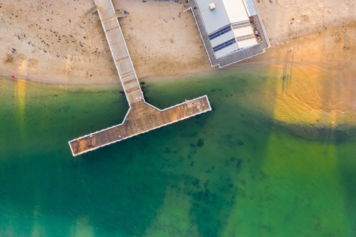 Aerial view of a people fishing on a T shaped jetty at the coast - Australian Stock Image