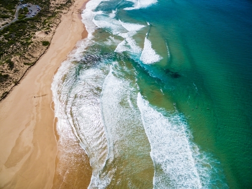 aerial view of beach with surfers in water - Australian Stock Image