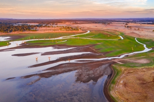 Aerial view of creeks and rivers flowing into a drying reservoir. - Australian Stock Image