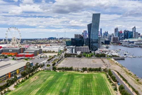 Aerial view of high rise buildings on a marina waterfront with a sporting field and car park - Australian Stock Image