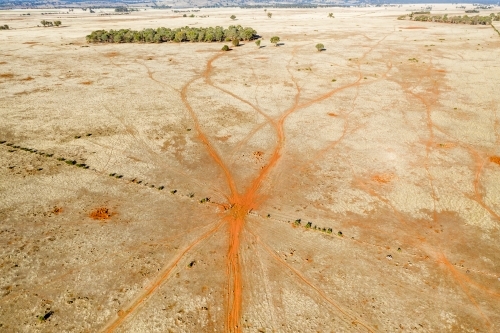 Aerial view of livestock tracks through a gateway in a barren paddock - Australian Stock Image