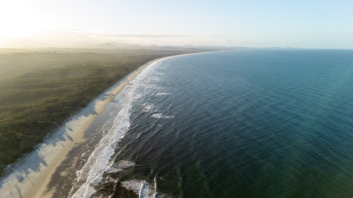 Aerial view of long stretch of white sand beach Byron Bay, New South Wales, Australia - Australian Stock Image