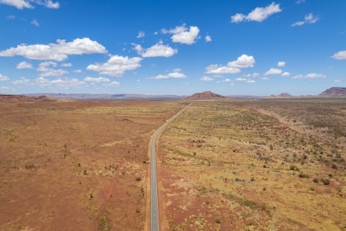 Aerial view of remote asphalt road that curves in the distance - Australian Stock Image