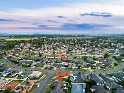 Aerial view over suburbia - streets and homes in country town at dusk - Australian Stock Image