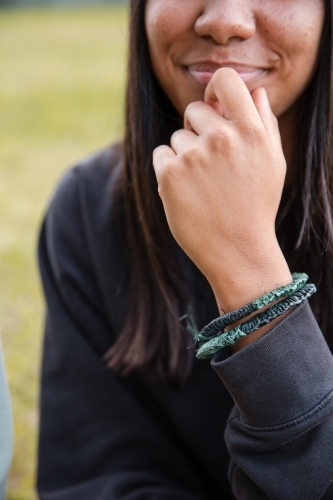 An Aboriginal girl wearing traditional, fibre, woven bracelets - Australian Stock Image