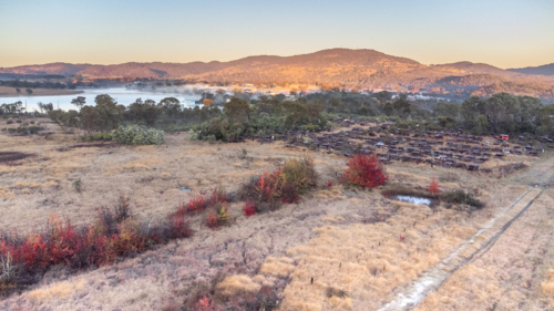 An aerial scene on a winter's morning over a dam, a junkyard and a mountain - Australian Stock Image