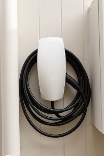 An electric vehicle car charger on the wall of a house - Australian Stock Image