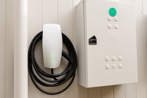 An electric vehicle car charger on the wall of a house with the switch break box next to it - Australian Stock Image