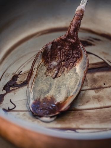 An empty bowl and spoon that has had chocolate icing  scraped out - Australian Stock Image