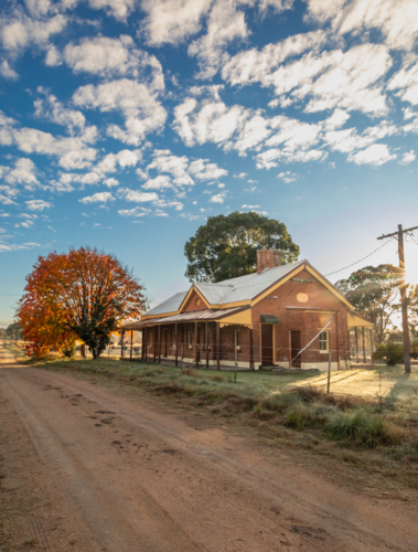 An old brick railway building with an autumn tree - Australian Stock Image