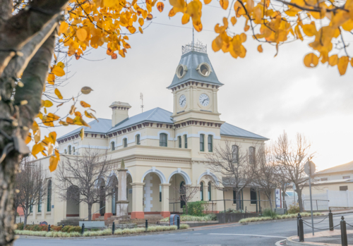 An old Post Office Building with a clock tower framed by autumn leaves - Australian Stock Image