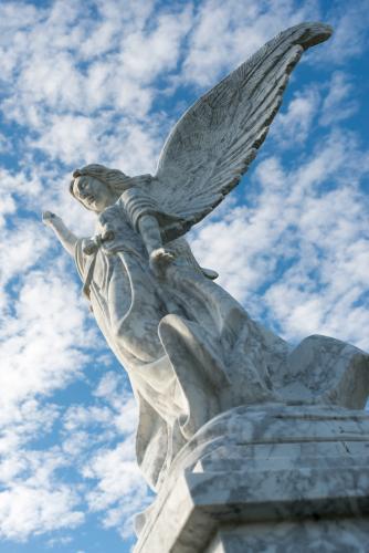 Angel on gravestone against clouded sky - Australian Stock Image