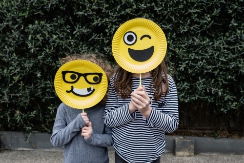 Anonymous children holding handmade happy emoji / emoticon masks - Australian Stock Image