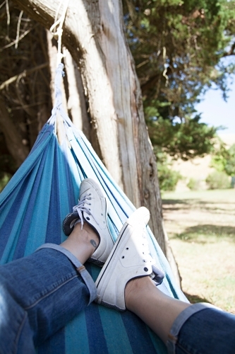 Anonymous woman's leg lazing in a hammock - Australian Stock Image