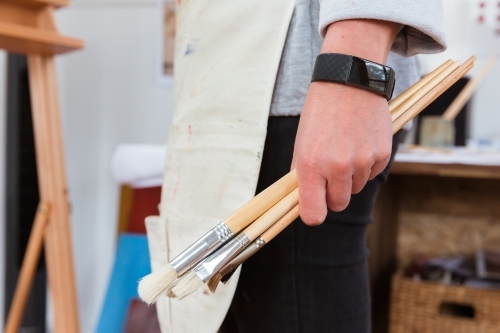 Artist holding brushes