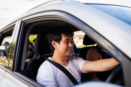 Asian Australian man driving his family in car - Australian Stock Image