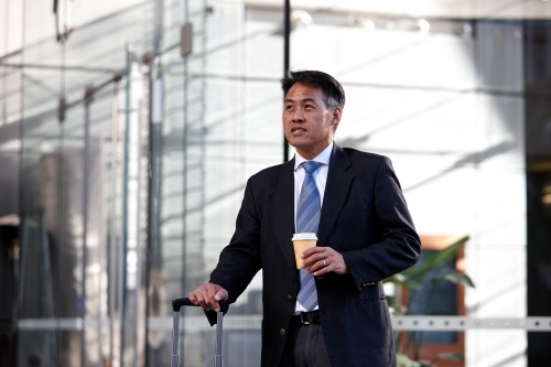 Asian businessman in city - Australian Stock Image