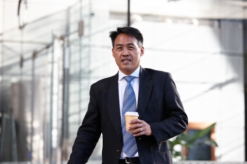 Asian businessman in city - Australian Stock Image